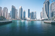 Sunny day cityscape of Dubai marina embankment with skyscraper.
