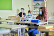 © gpointstudio - School children raising arms in class