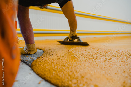 Worker applying epoxy and polyurethane flooring system