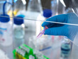 © Andrew Brookes/Westend61 - Scientist holding vial containing chemical formula ready for analysis in fume hood
