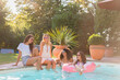 © Annika List/Westend61 - Cheerful female friends having fun in swimming pool during sunny day