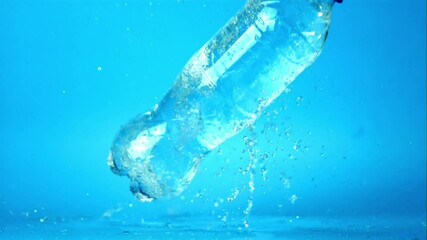 Canvas Print - Super slow motion with splashes on the table drops a bottle of water. Filmed on a high-speed camera at 1000 fps.On a blue background.