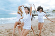 © Alex Rodriguez Taus/Westend61 - Cheerful female friends having fun at beach during vacations