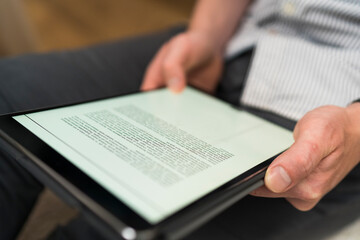 Businessman reading document over digital tablet while working at home