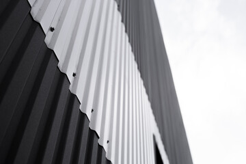 Wall Mural - Black and white corrugated iron sheet used as a facade of a warehouse or factory. Texture of a seamless corrugated zinc sheet metal aluminum facade. Architecture. Metal texture.