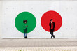 © Emma Innocenti/Westend61 - Two circles visualizing social distancing covering man and woman standing outdoors with smart phones in hands