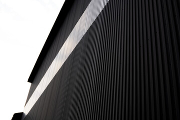 Wall Mural - Black and white corrugated iron sheet used as a facade of a warehouse or factory. Texture of a seamless corrugated zinc sheet metal aluminum facade. Architecture. Metal texture.