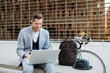 © Gerard Moral Casanovas/Westend61 - Male professional working on laptop while sitting on bench