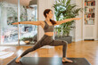 © Gerard Moral Casanovas/Westend61 - Woman practicing warrior 2 yoga pose at home