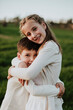 © Gala Mart√≠nez L√≥pez/Westend61 - Loving brother and sister embracing at grassy field