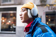 © Jose Carlos Ichiro/Westend61 - Asian man listening music through headphones outdoors