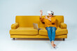 © OneInchPunch/Westend61 - Senior woman with laptop using virtual reality headset while sitting on sofa