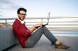© Rafa Cort√©s/Westend61 - Smiling male business professional with laptop sitting on pier leaning against bench