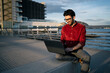 © Rafa Cort√©s/Westend61 - Smiling male freelance worker using laptop on bench