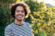 © steve brookland/Westend61 - Young man smiling while standing in garden