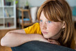 © steve brookland/Westend61 - Contemplating redhead girl sitting on chair at home