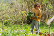 © steve brookland/Westend61 - Woman holding vegetables in permaculture garden