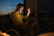 © Uwe Umst√§tter/Westend61 - Smiling young man in wheelchair gesturing while making video call through digital tablet sitting on wheelchair in living room