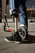 © Veam/Westend61 - Disabled young man with prosthetic leg standing by electric push scooter in city