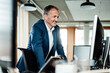 © Gustafsson/Westend61 - Smiling businessman working on computer in office