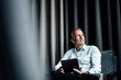© Gustafsson/Westend61 - Contemplating businessman with digital tablet looking away while sitting on armchair in office cafeteria