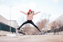 Cheerful Girl Jumping On Road Against Sky