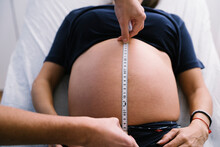 Female Nurse Measuring Pregnant Woman Abdomen With Measuring Tape