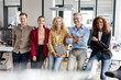 © peter scholl/Westend61 - Smiling male and female colleagues leaning at desk in office