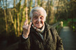 © Ramon Espelt/Westend61 - Cheerful elderly woman gesturing horn sign on sunny day