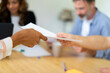 © VITTA GALLERY/Westend61 - Coworkers passing document to each other at office