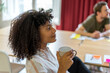 © VITTA GALLERY/Westend61 - Young Afro female entrepreneur holding mug during meeting at office