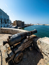 Old Cannon By Bay Of Sea In City At Monopoli, Apulia, Italy