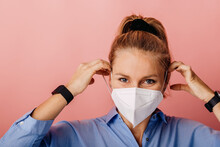 Businesswoman Wearing Protective FFP2 Face Mask While Standing Against Colored Background
