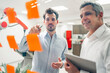 © Daniel Ingold/Westend61 - Young male engineer explaining business plans to smiling mature man in front of adhesive notes on glass wall in factory