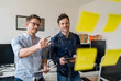 © Daniel Ingold/Westend61 - Smiling male colleagues discussing over adhesive notes at office