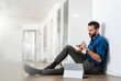 © Daniel Ingold/Westend61 - Businessman eating food while sitting by digital tablet on floor at office