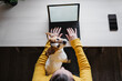 © Eva Blanco/Westend61 - Woman sitting with dog while while working on digital tablet at home office
