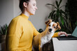 © Eva Blanco/Westend61 - Young woman working on digital tablet while sitting with pet at home office