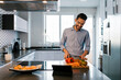 © Ezequiel Gim√©nez/Westend61 - Smiling man with vegetables standing at kitchen counter