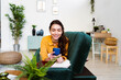 © Giorgio Fochesato/Westend61 - Woman smiling while using mobile phone lying on sofa at home