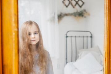 Wall Mural - reflection in the mirror little red haired girl sitting in a country house on a bed, summer vibes concept