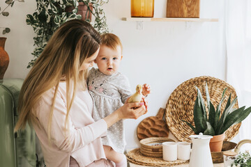 Wall Mural - mom young woman and her little girl daughter stands in the kitchen of a country house with duckling in hands and bathing in sink, summer vibes concept