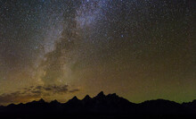 The Milky Way Galaxy Extends Into The Night Sky From The Teton Mountains In Grand Teton National Park, Wyoming.