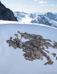 A group of climbers trek across the glacier ridge line after descending from the Becky-Chouinard Route on the Howser towers in Bugaboos, British Columbia, Canada
