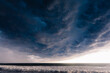 © Tandem Stock - A Cumulonimbus Mammatus storm cloud crawling pushing away the sunny evening in what will soon be a giant thunder storm in La Libertad, El Salvador.