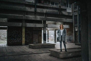 Sticker - Young Caucasian female wearing a coat standing in an old building