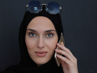 Young muslim businesswoman in traditional clothes or abaya talking on the smartphone