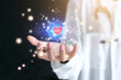 © jayzynism - Male cardiologist with red heart and virtual screen in his hand. Medical icon network connection virtual screen interface