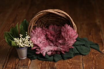 Newborn photography digital background prop. Wood basket with pink fur and flowers on a wooden background