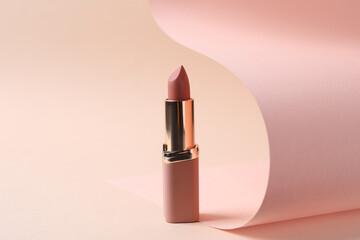 Wall Mural - Beautiful lipstick on beige background. Professional makeup product